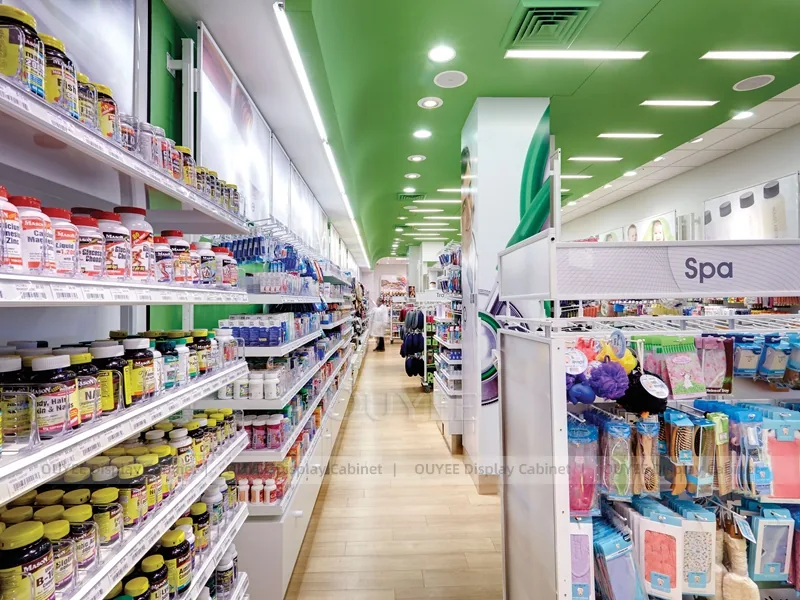 Stocked pharmacy aisle with product shelving and green ceiling accents