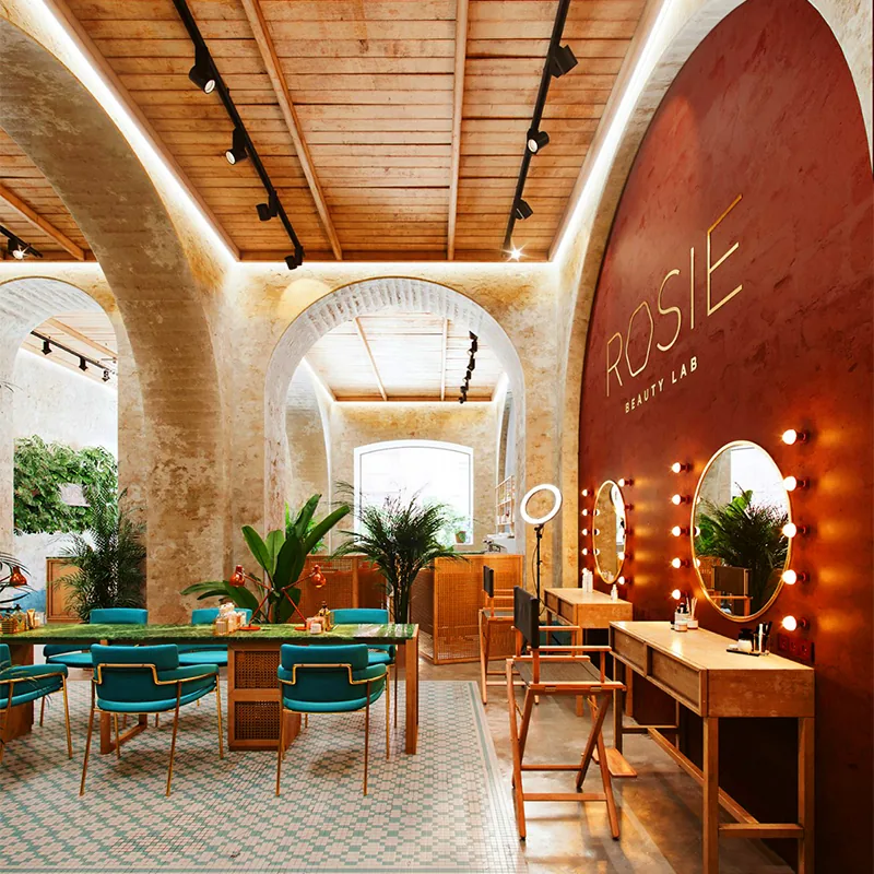 Luxuriöse Beauty-Salon-Lounge mit türkisfarbenen Stühlen und Produktpräsentationen_06