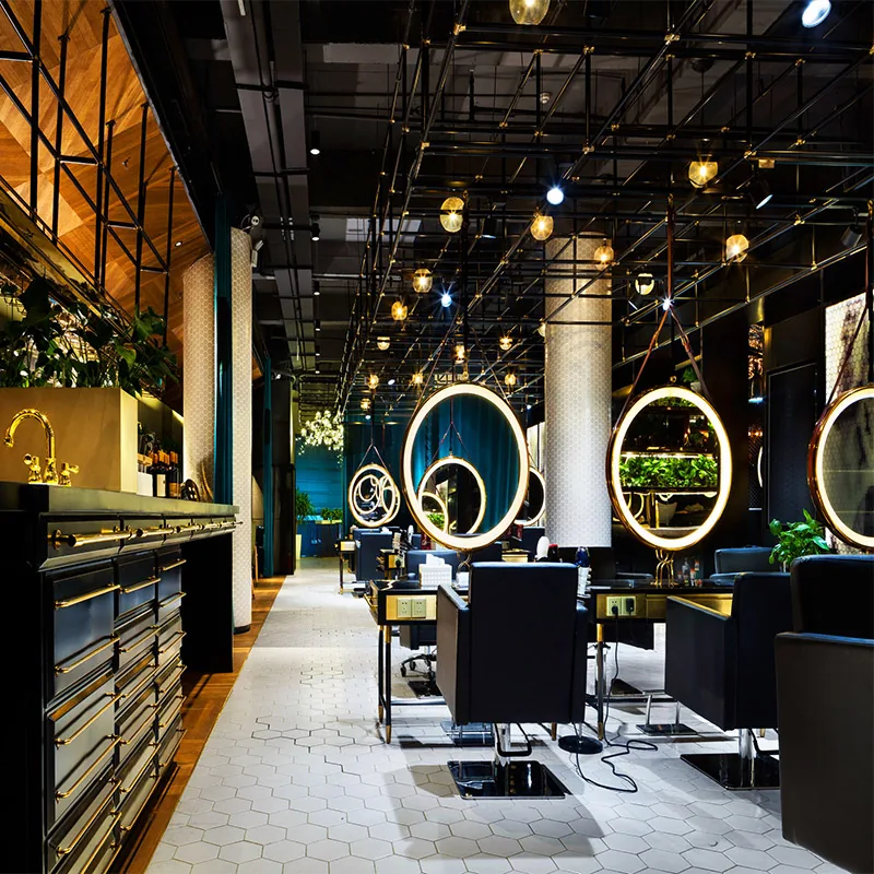 Interno salone moderno con specchi circolari illuminati e sedie nere_01