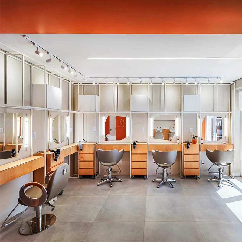 Orangefarbener Salon-Waschbereich mit Holzschränken und weißen Regalen_02