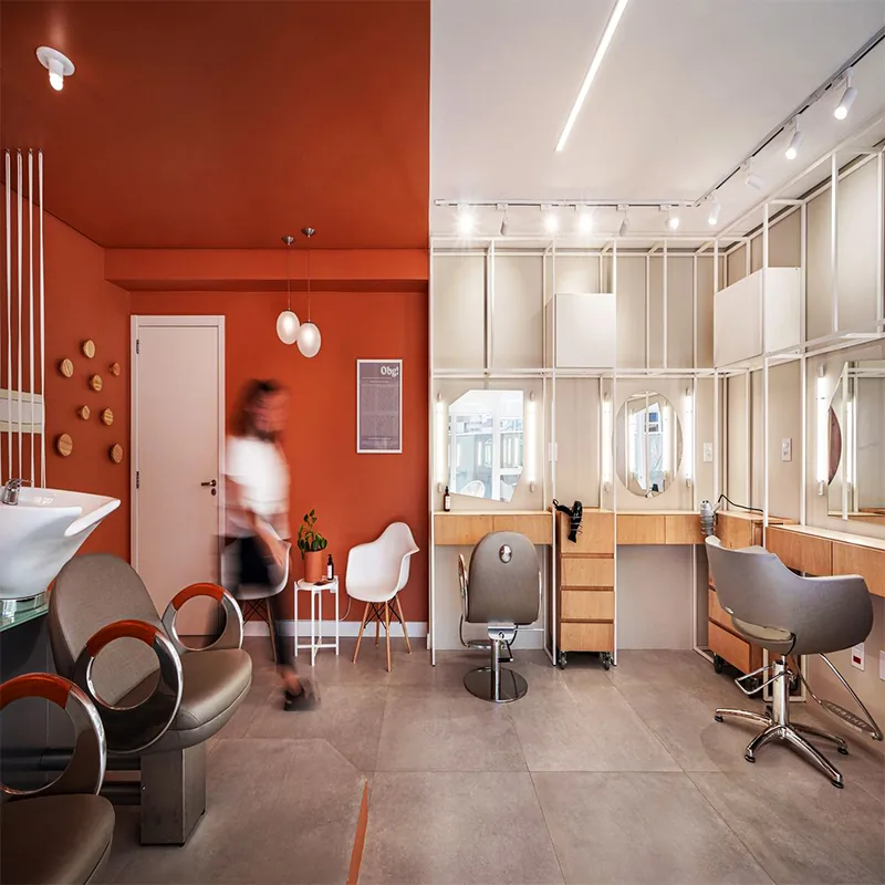 Orangefarbener Salon-Waschbereich mit Holzschränken und weißen Regalen_05