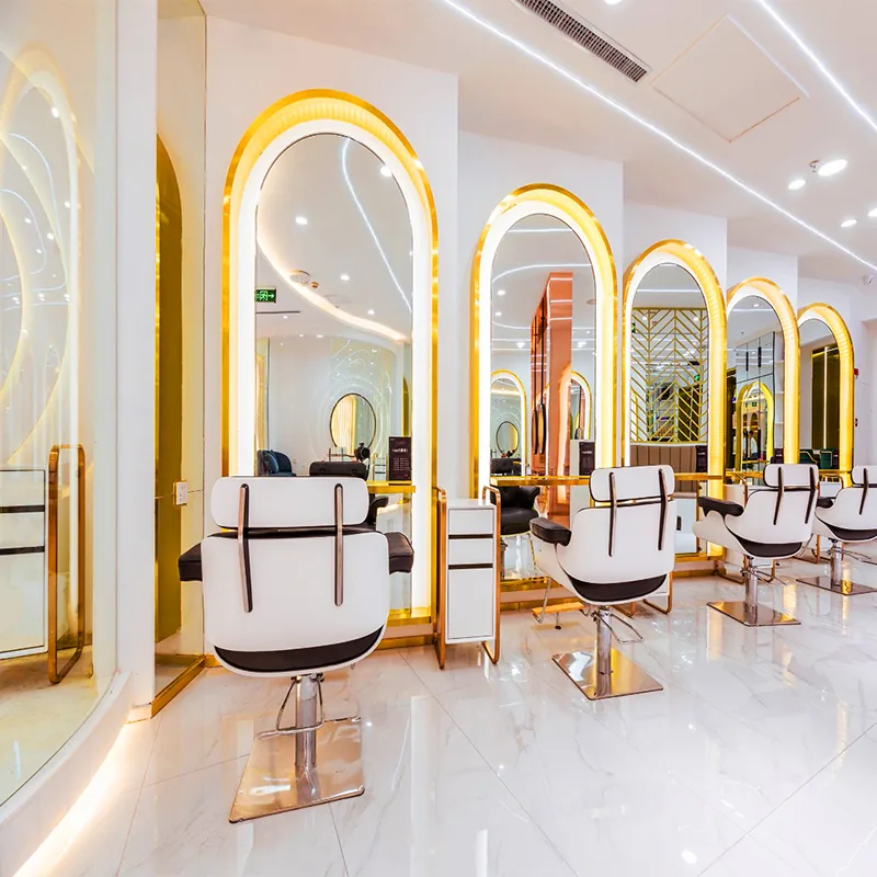 Postazioni styling bianche e oro in salone con specchi ad arco illuminati_01